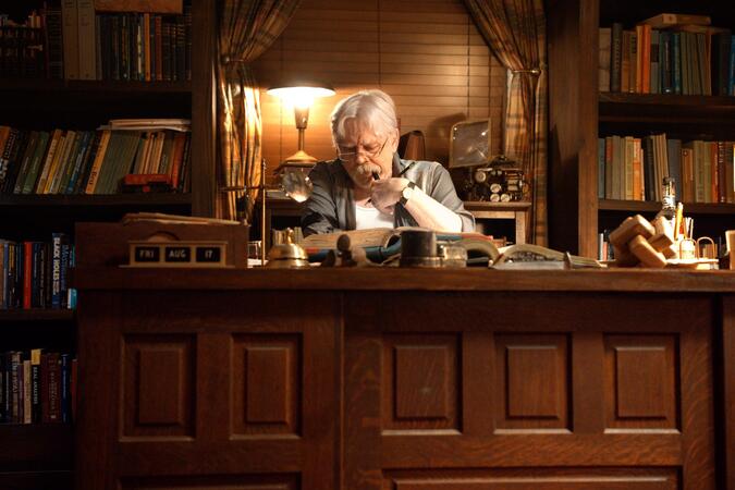 Mark Hamill sitzt an einem Schreibtisch im Film The Life of Chuck