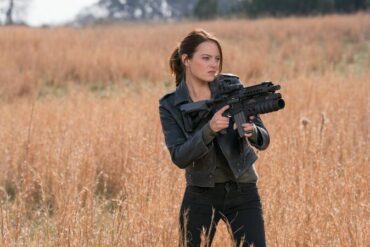 Emma Stone, schwarz gekleidet, mit einer Waffe in Zombieland 2