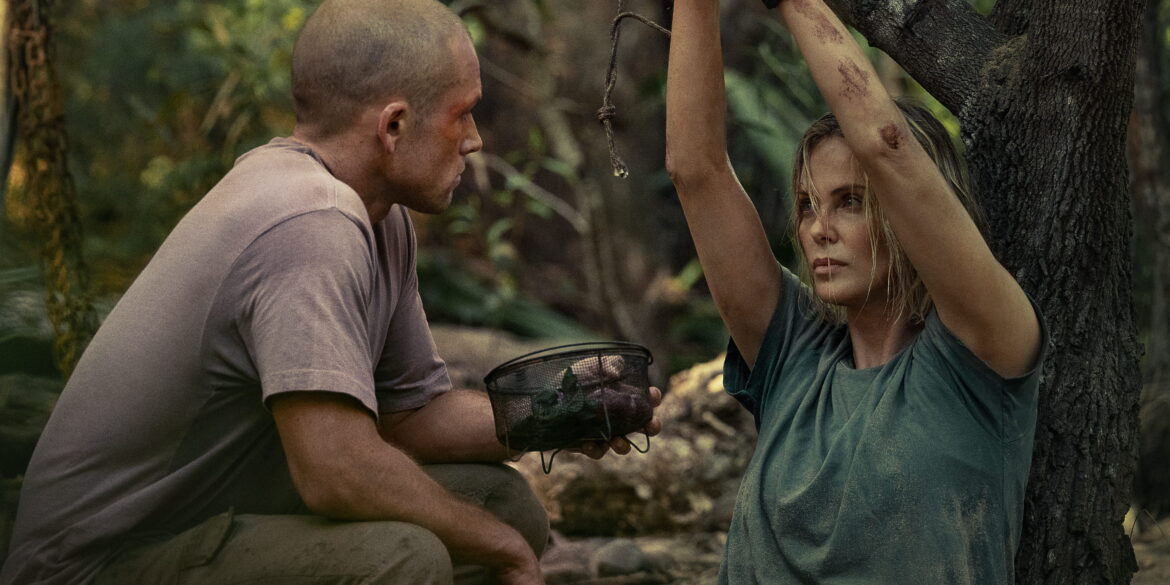 Ein Mann redet mit einer Frau, die in einem Dschungel an einen Baum gefesselt ist.